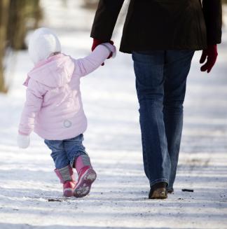child walking with adult in winter on snow