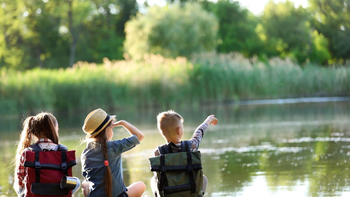 children sitting at lakeshore