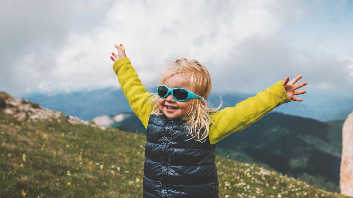 girl with raised arms on mountain