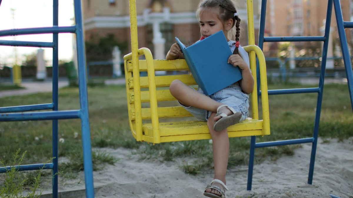 girl reading on swing