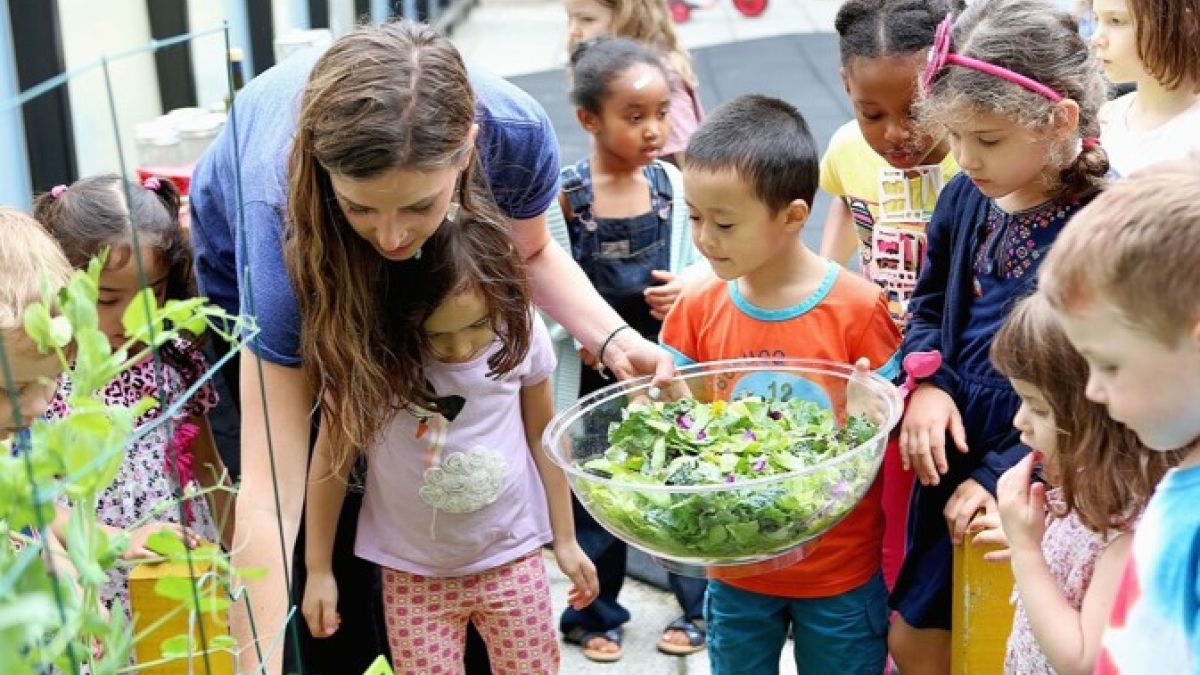 teacher with young children in outdoor garden