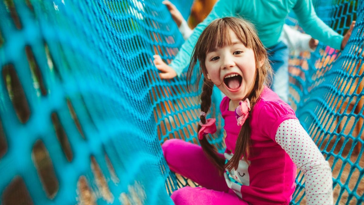 young girl playing on net bridge