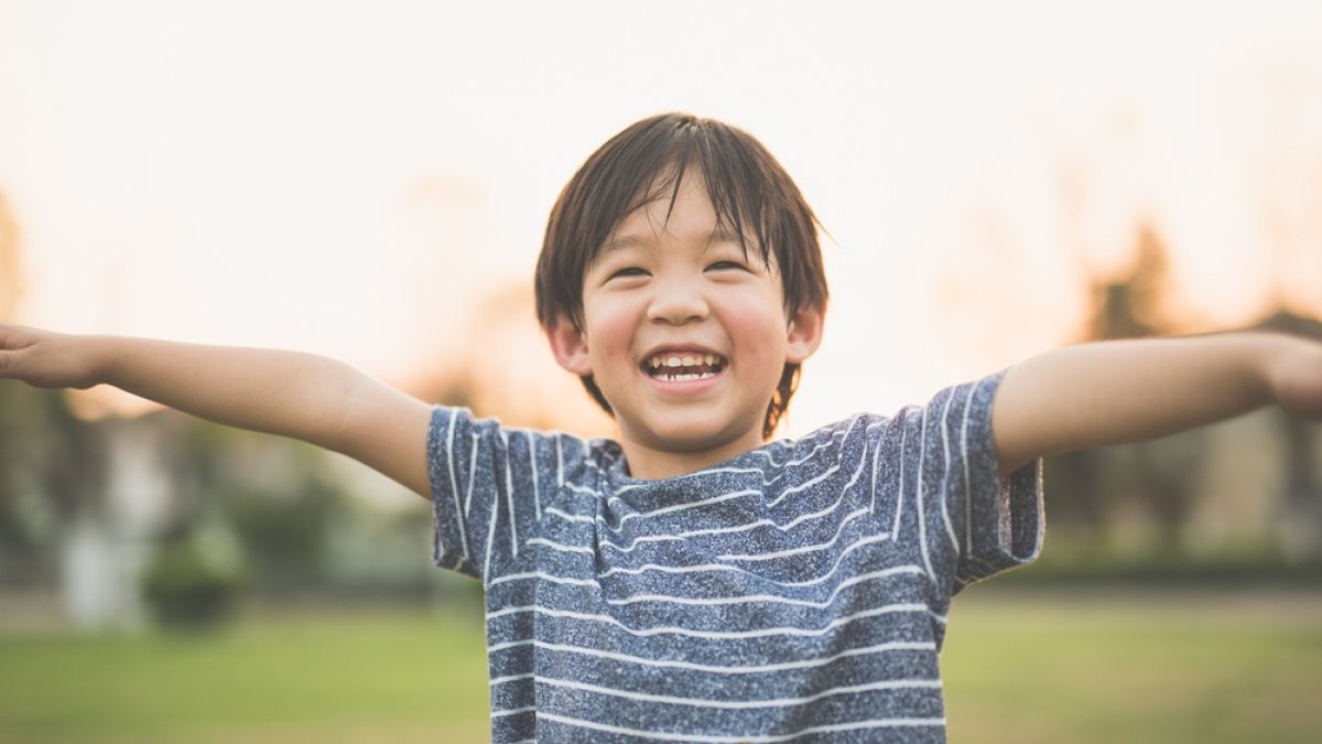 Young boy smiling with arms open wide