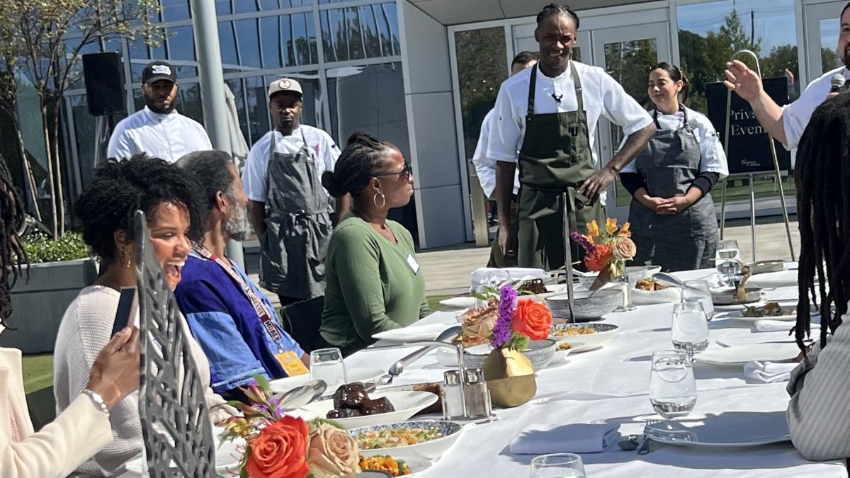 picture of people sitting at a table outside for a farm-to-table lunch at the inaugural Seeds of Justice meeting