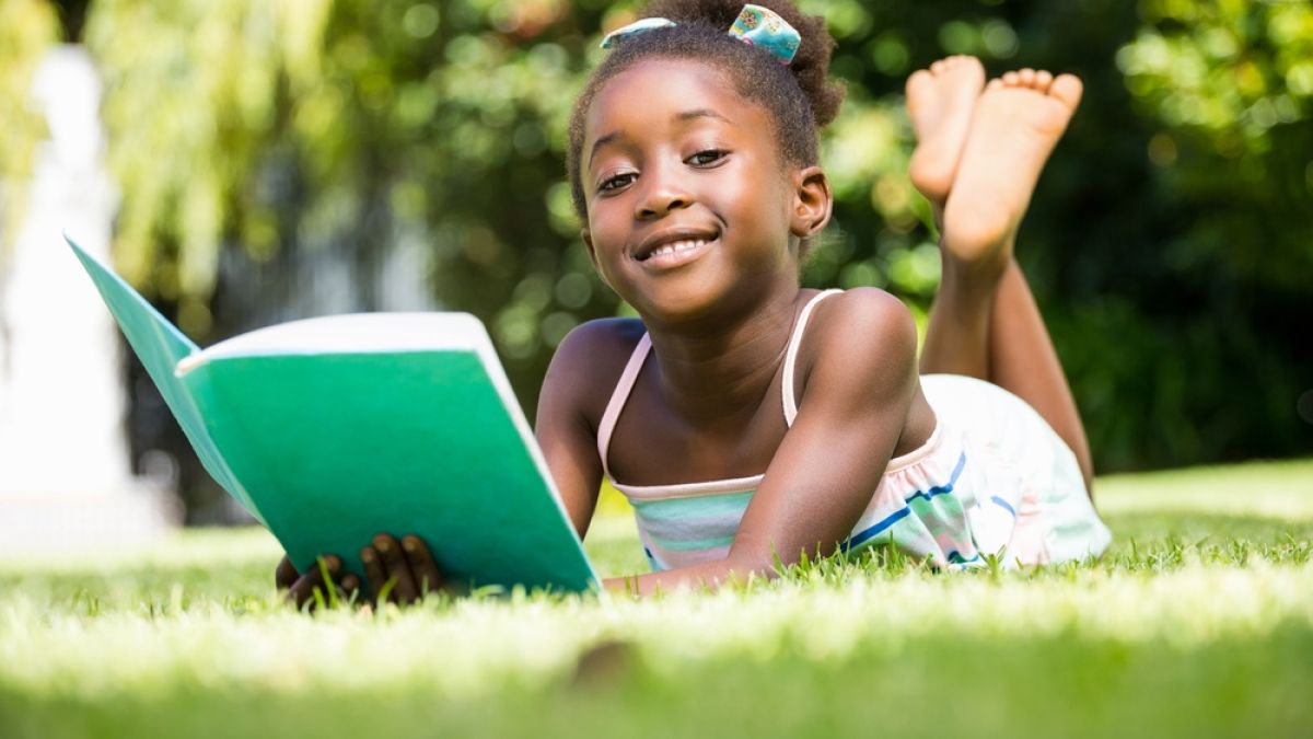 young black girl reading outside