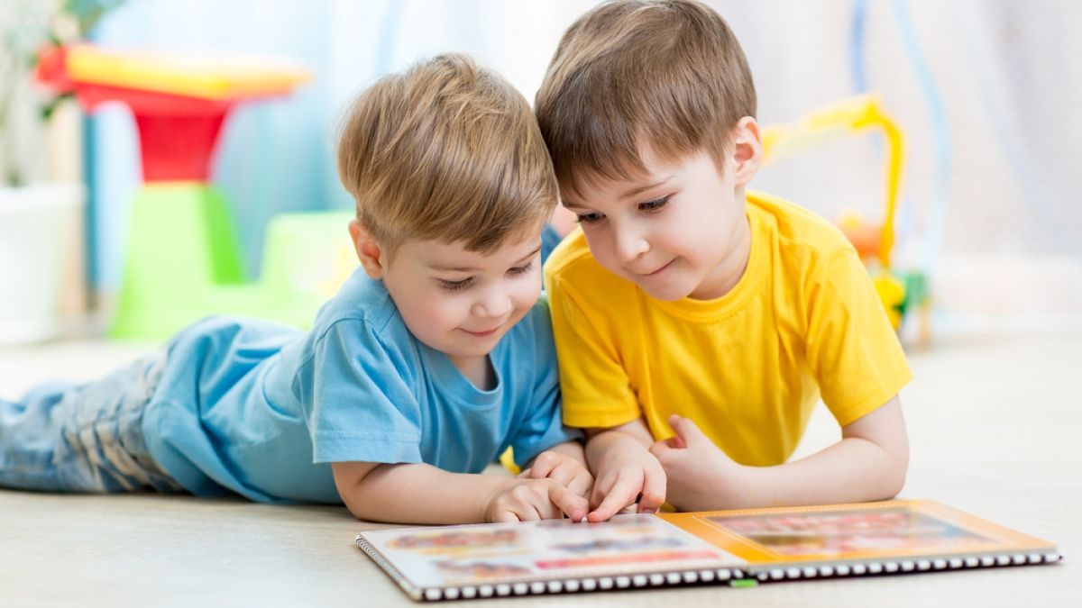 two young boys reading storybook