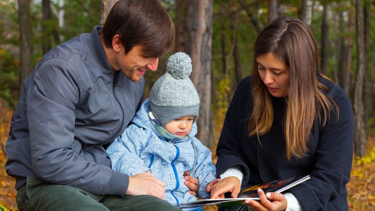 Young mother and father and son walk in the autumn park
