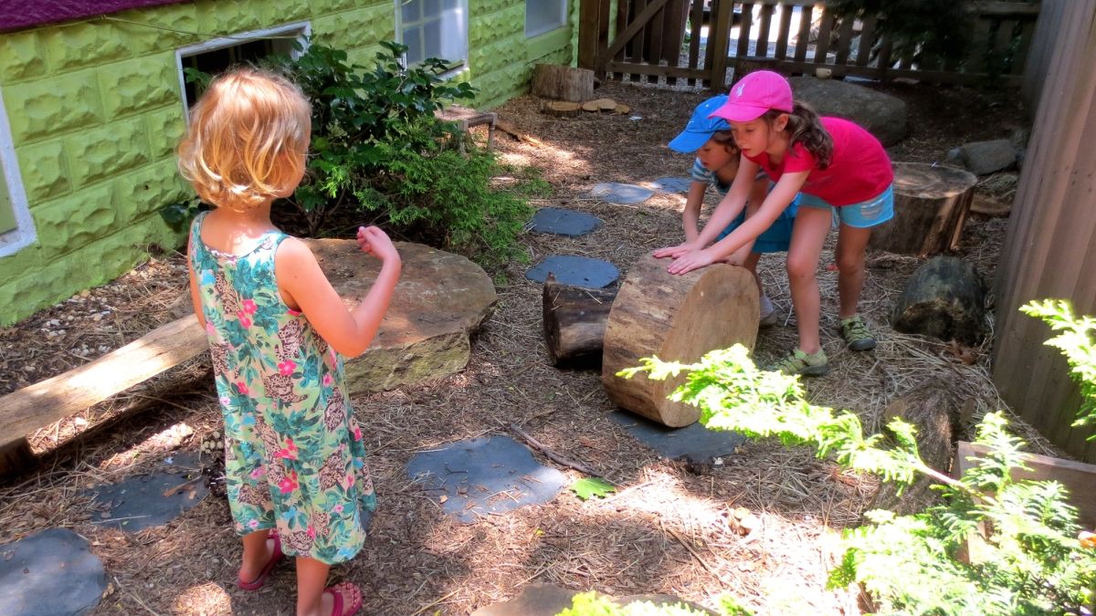 Children move a stump to another part of the yard.