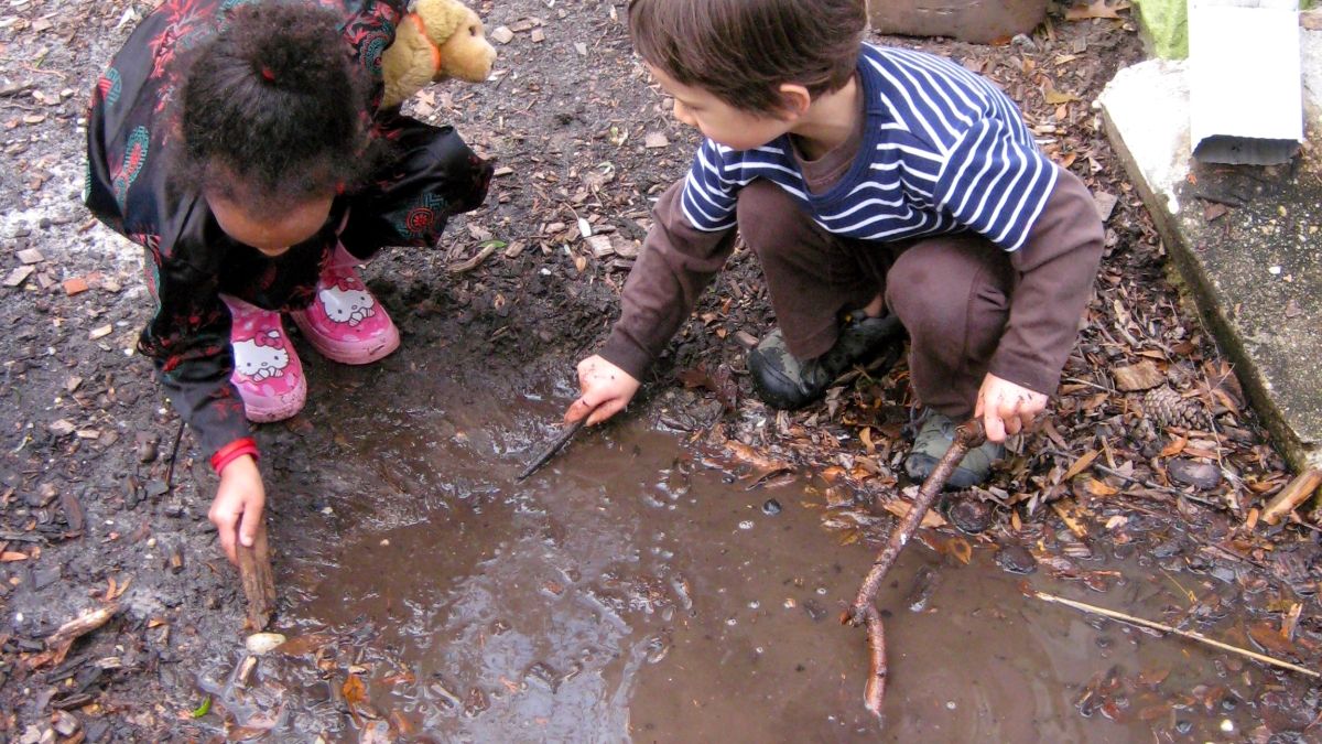 Children play in their mud aquarium.