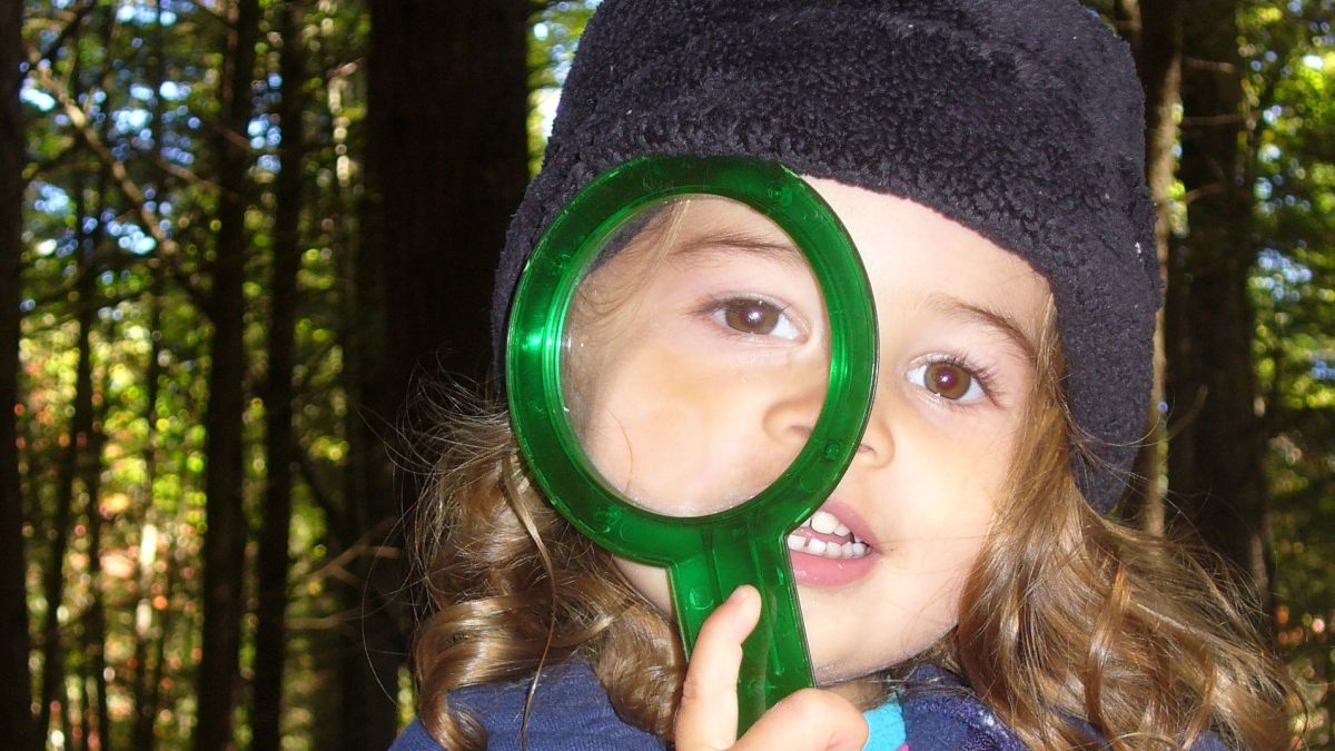 Wild Roots students explore with magnifying glasses and other tools.
