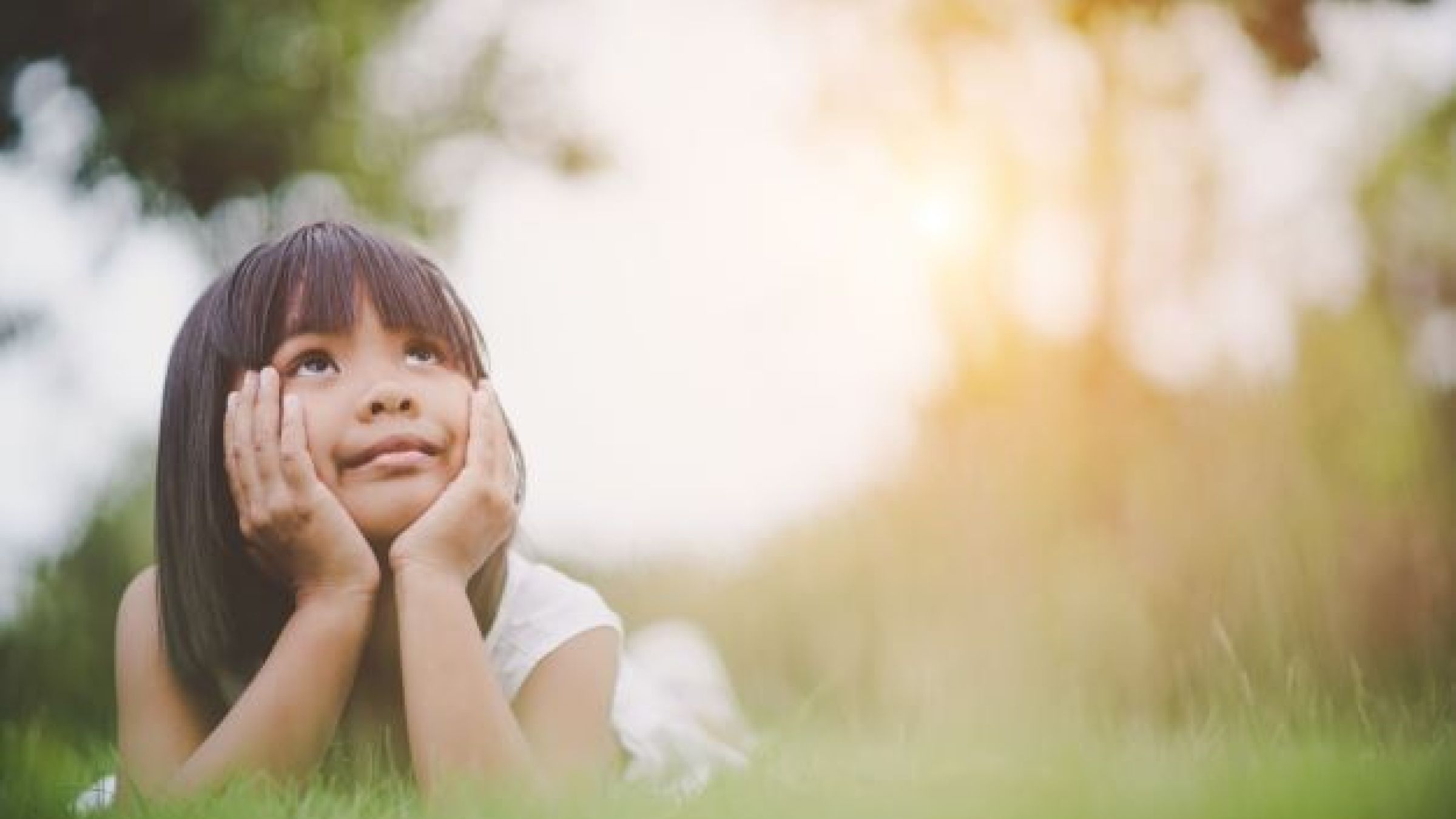 girl laying on grass looking up