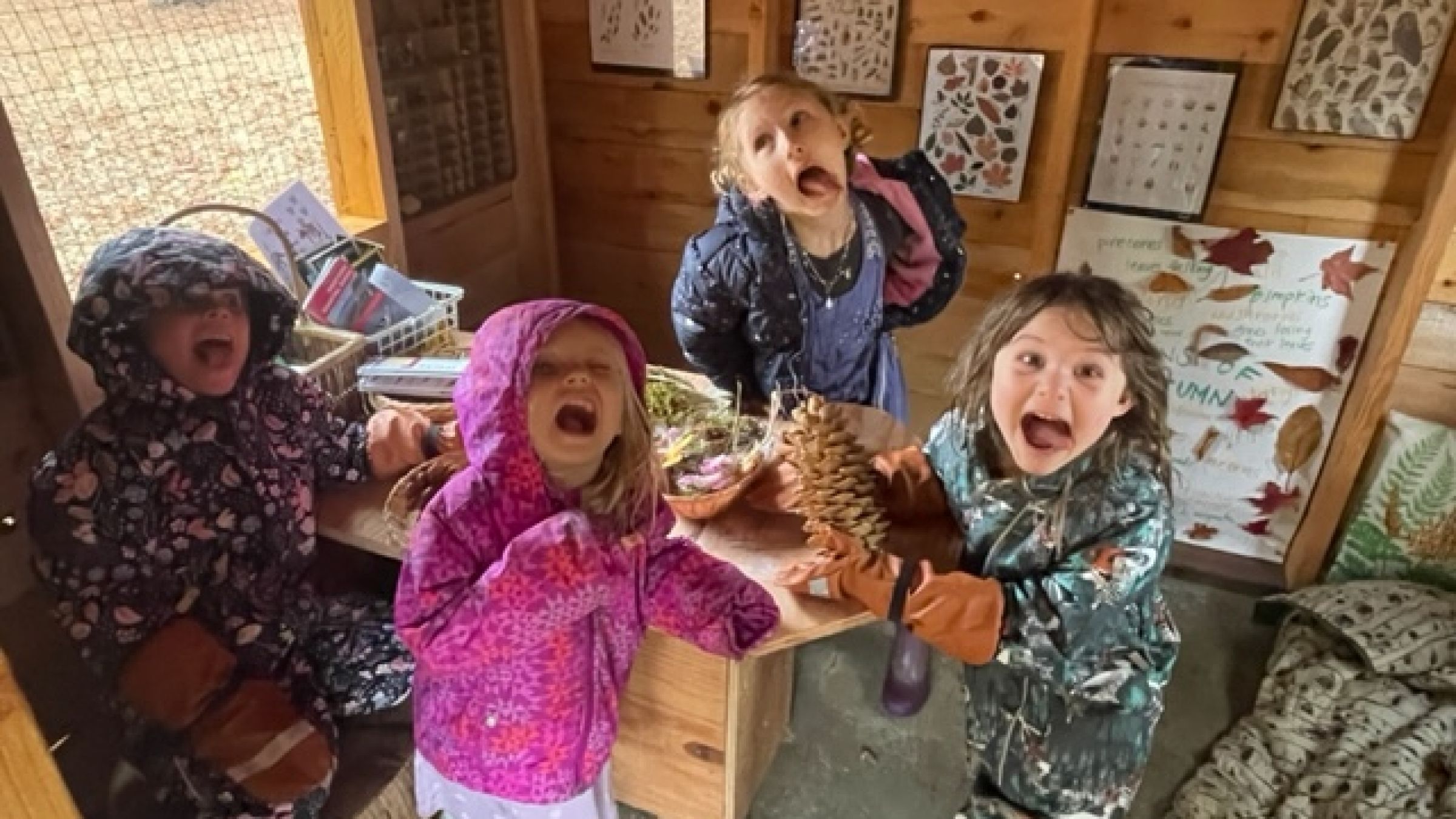 children in an outdoor shed poking their tongues out at the camera