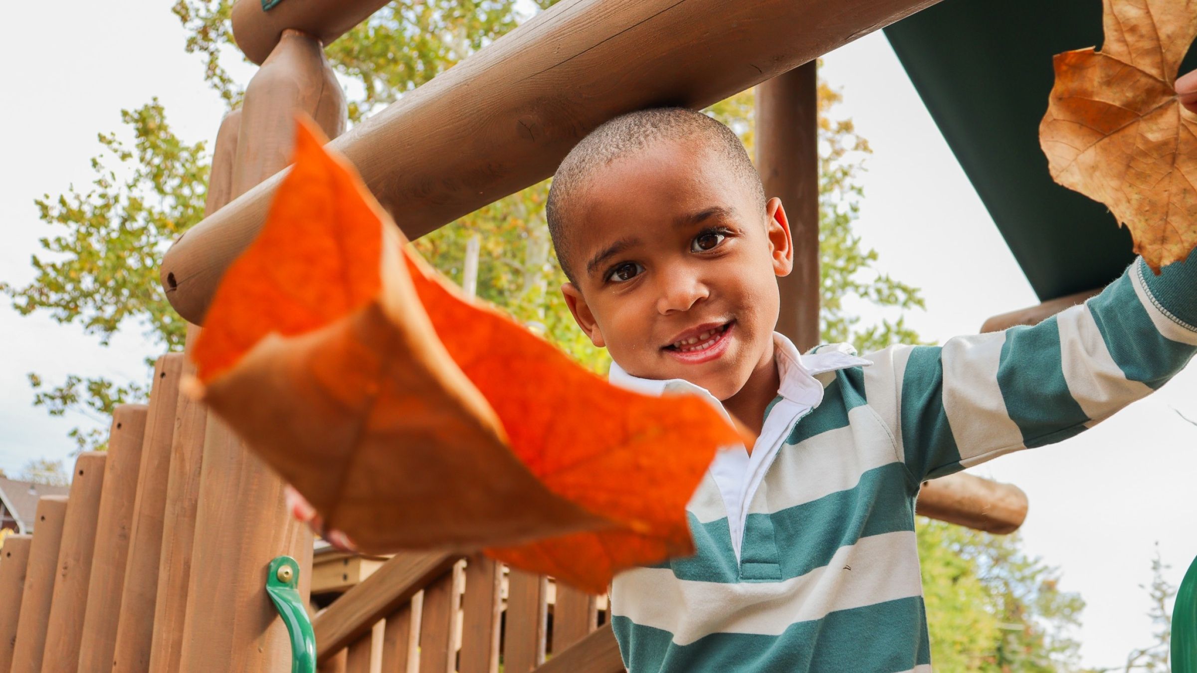 young black child playing with leaves