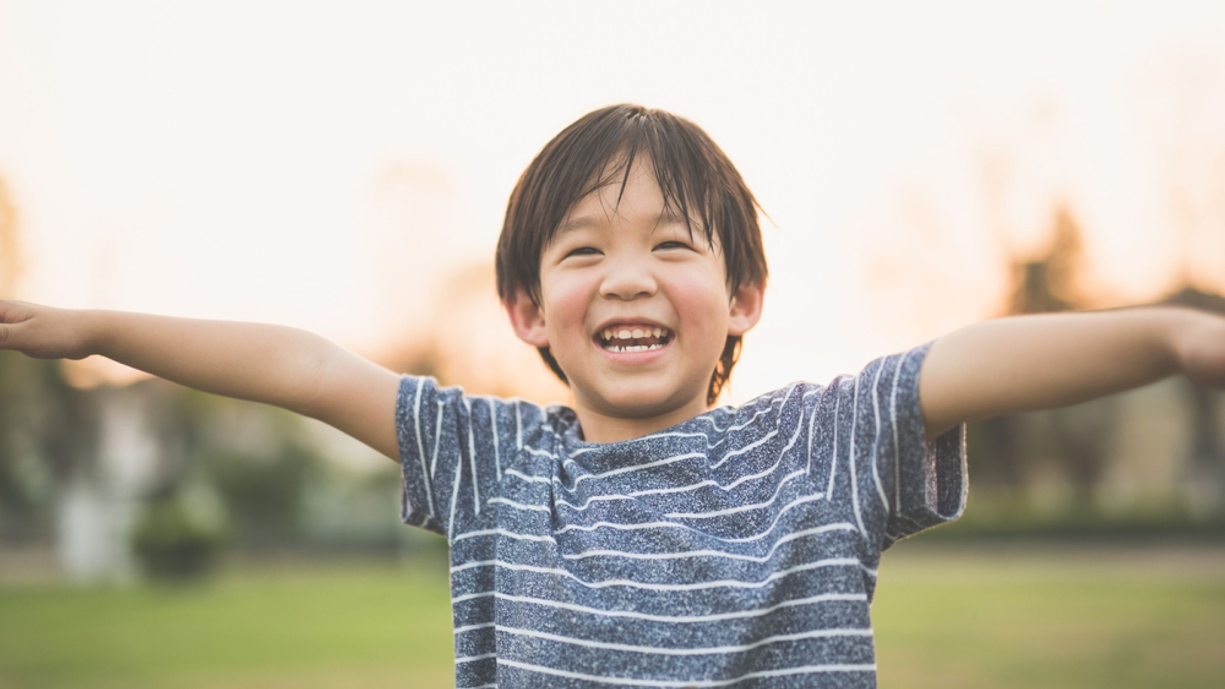 Young boy smiling with arms open wide