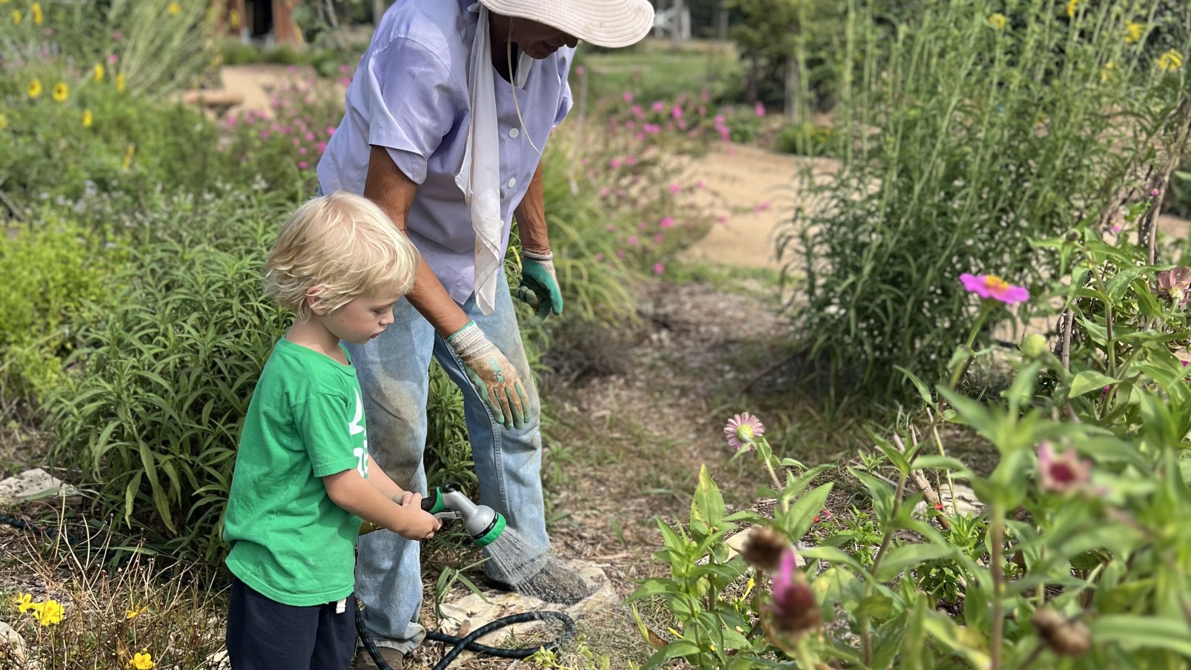 child gardening with adult