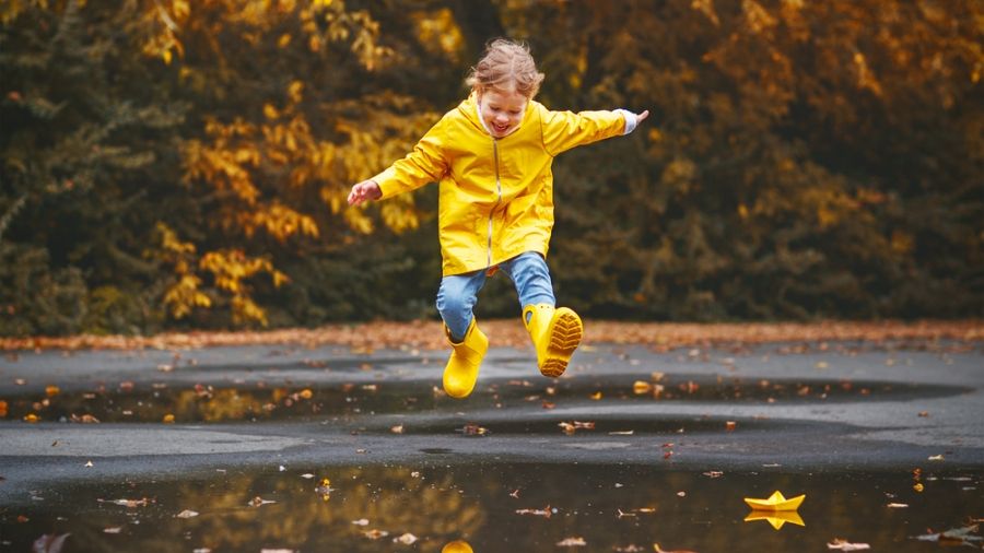 young girl jumping in puddle