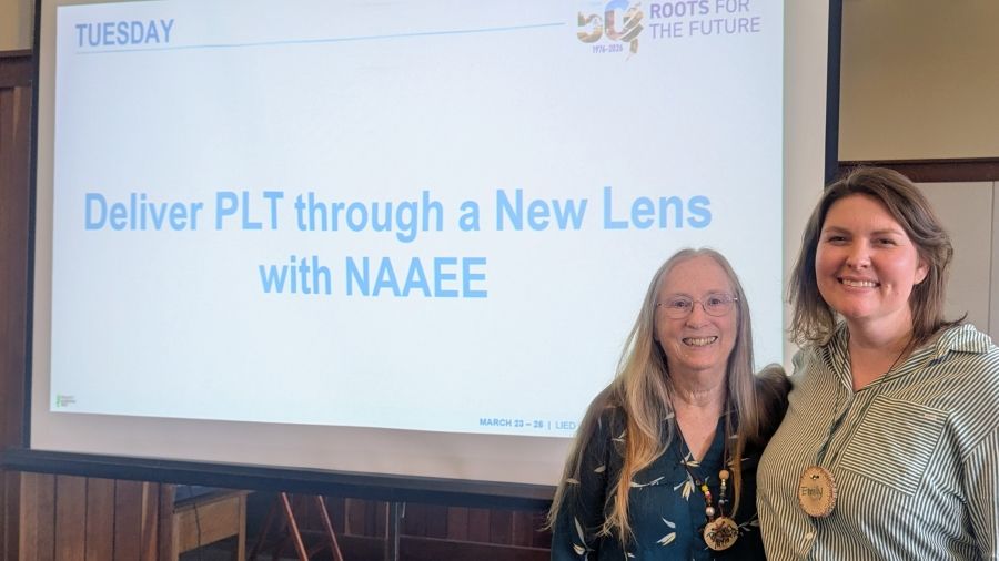 Presenters standing in front of title slide on screen