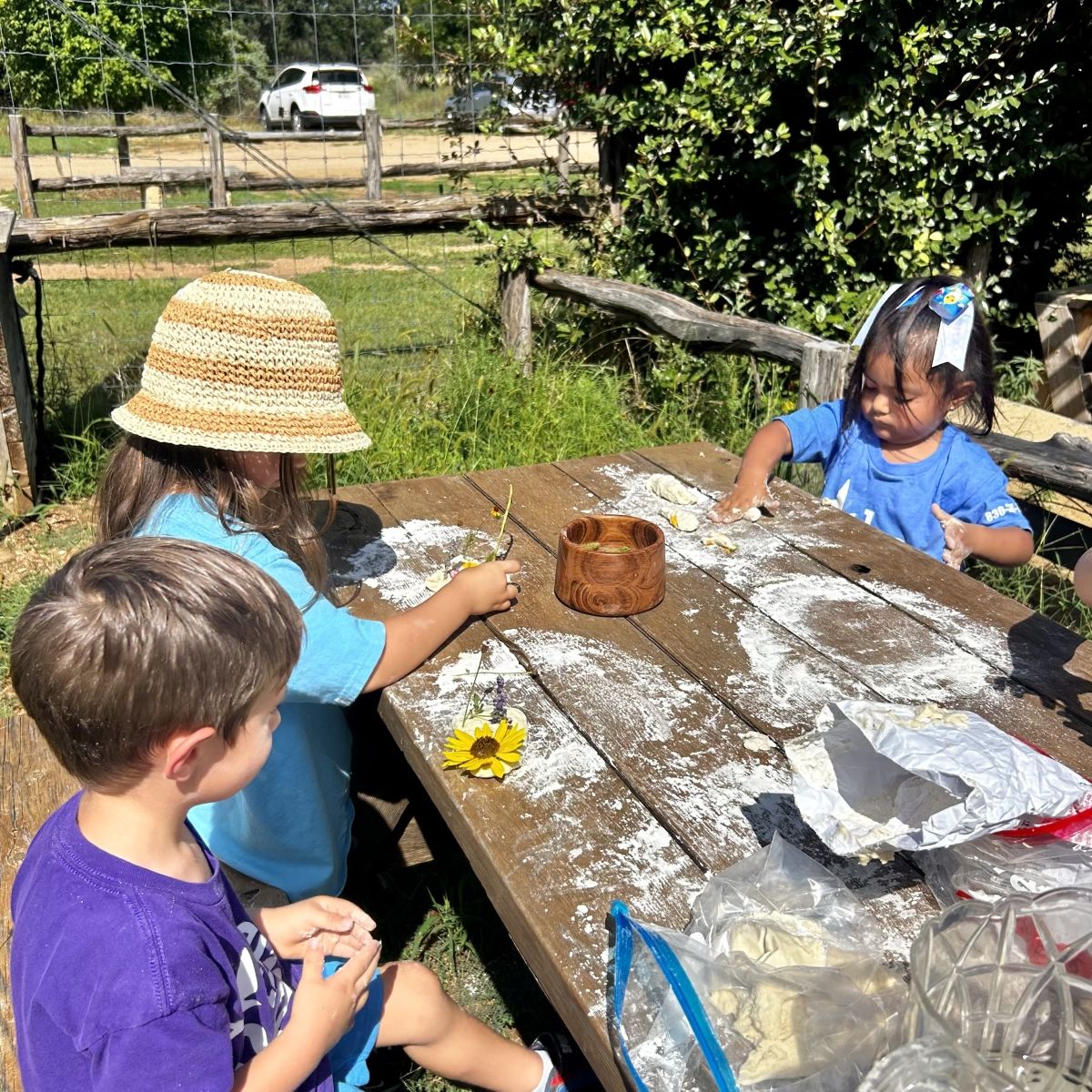 children sitting at picnic table working on craft