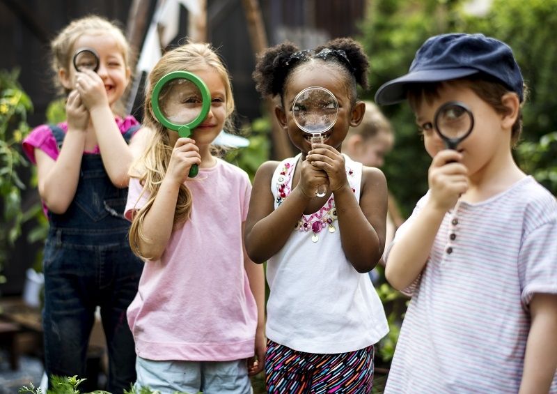 children looking through magnifying glasses