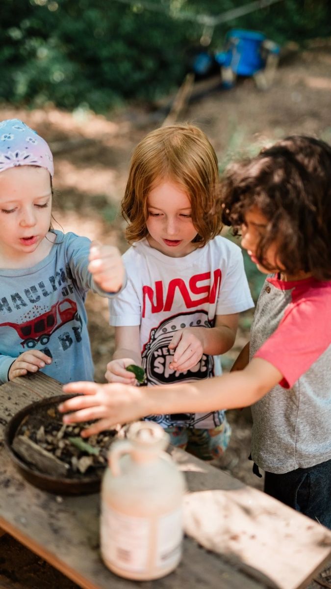 children engaged in a craft activity in the woods