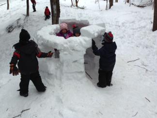 Ottauquechee students building a forest igloo.