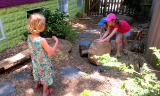 Children move a stump to another part of the yard.