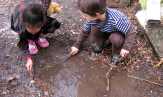 Children play in their mud aquarium.