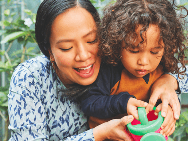 parent helping young child water plant