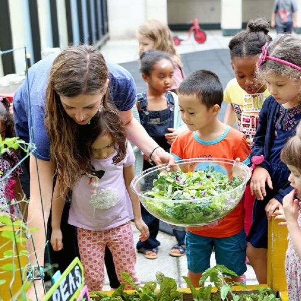 teacher with young children in outdoor garden