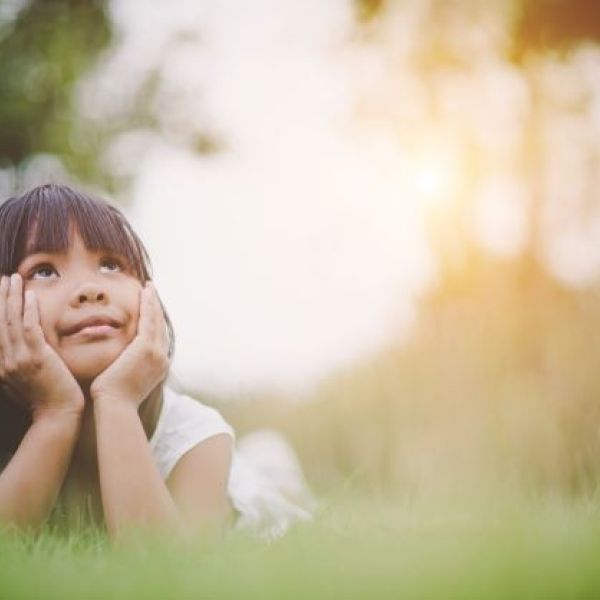 girl laying on grass looking up