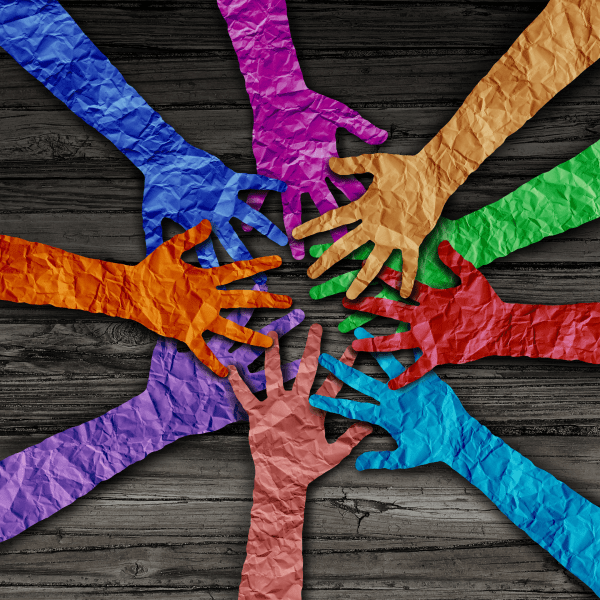colorful paper hands reaching toward center of table