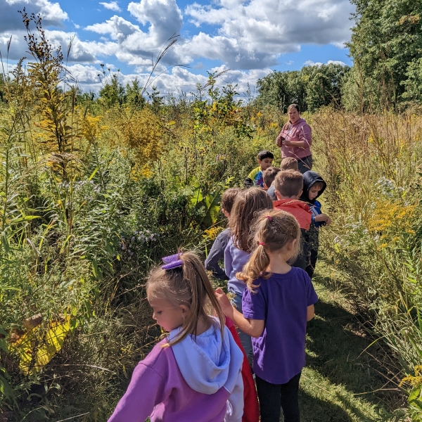 children walking with teacher in a prairie