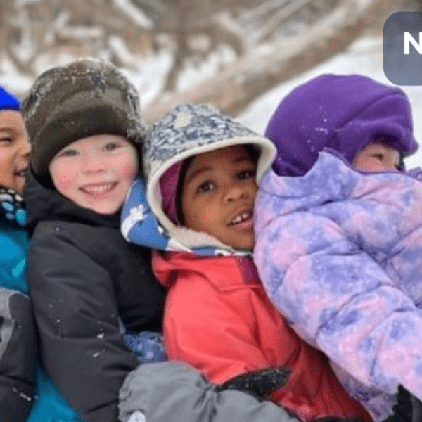 children sitting in a line leaning on one another