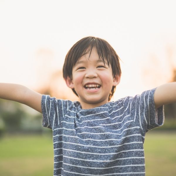 Young boy smiling with arms open wide