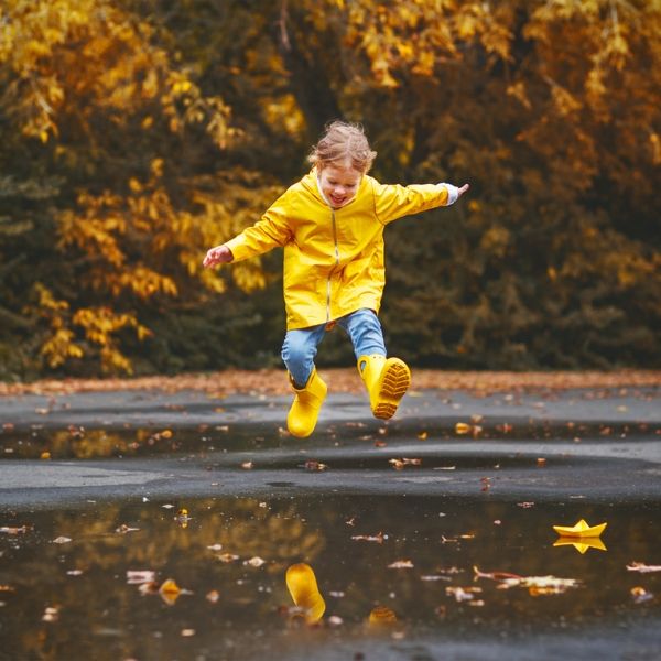 young girl jumping in puddle