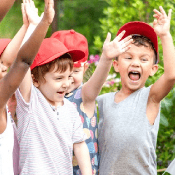 children expressing enthusiasm toward teacher kneeling next to them