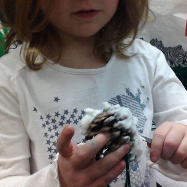 A Primary Photo Journalist records her partner's work during an activity to create bird feeders for the school yard.